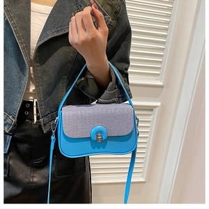 Détail du sac à main bleu avec rabat rayé et fermoir métallique argenté pour femmes