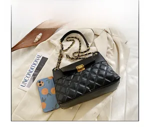 Detailaufnahme der schwarzen Stepptasche mit goldener Kette und Schnalle auf Stoff