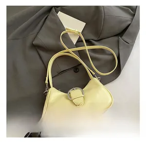Detail view of the yellow hobo bag showing the silver metal buckle and adjustable strap