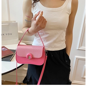 Dettaglio borsa in pelle rosa con patta intrecciata e chiusura a girello in metallo