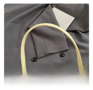 Close-up of comfortable smooth handle and metal zipper on light yellow leather handbag