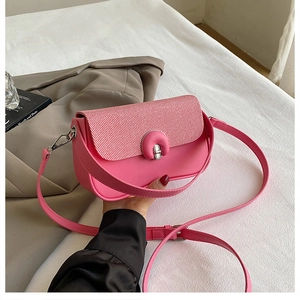 Gros plan détaillé du sac selle rose avec fermoir rotatif argenté et texture en cuir