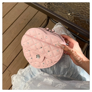 Détail du sac à main rose matelassé avec strass et fermoir en métal camélia argenté