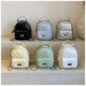 Detailed display of mini quilted backpacks in six colors on minimalist stone steps