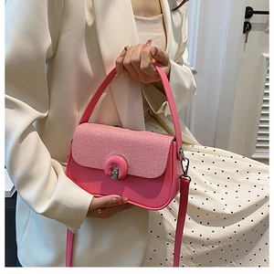 Détail d'un sac fuchsia en cuir avec rabat tressé et fermoir rotatif en métal chic