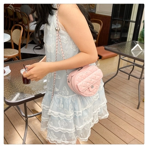 Vue détaillée du sac en cuir matelassé rose en forme de cœur avec fermoir fleuri