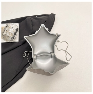 Detail view of silver star shaped acrylic box bag showing inner compartment and chain strap