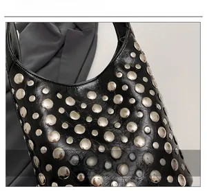 Detailed macro shot of vintage black crinkled leather with silver rivet studs on handbag