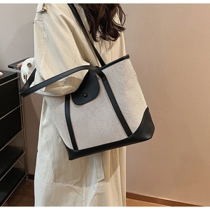 Détail du sac fourre-tout en toile minimaliste avec bordure et bandoulière en cuir noir