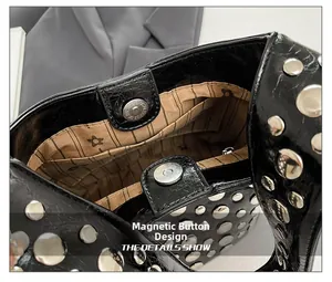 Close-up of black rivet handbag with magnetic button closure and floral stripe lining