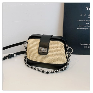 Detail of straw texture contrast crossbody bag with silver twist lock and chain strap