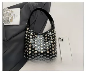 Top view of a black studded leather bucket bag with silver rivets and size reference