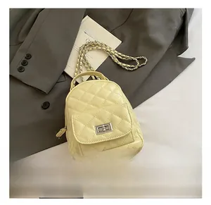 Detail showing the cream quilted leather texture and metal chain strap of the stylish backpack