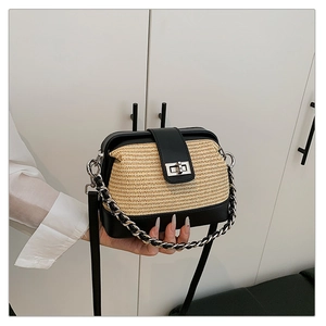 Detail of color-block woven crossbody bag featuring a silver chain and vintage metal clasp