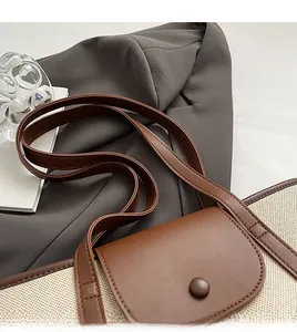 Détail des coutures en cuir marron et du fermoir magnétique sur le sac en toile