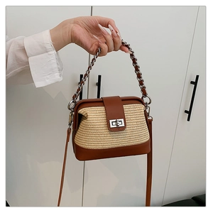 Close-up of woven crossbody bag with brown leather trim and silver metal twist lock