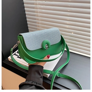 Détail d'un sac à main en cuir vert avec rabat tissé bleu clair et fermoir métallique