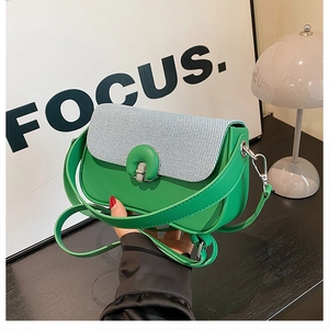 Détail du sac à main en cuir vert avec tissu bleu-blanc et boucle ronde en métal