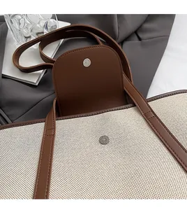 Détail du fermoir magnétique et de la texture en toile sur un sac cabas vintage