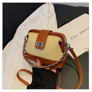 Close-up of contrast woven crossbody bag with brown leather trim and silver clasp