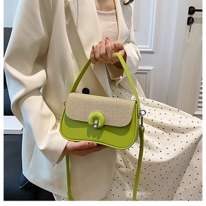 Sac bandoulière en cuir vert et paille porté par un mannequin en costume blanc