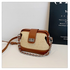 Close-up of contrast beige straw and brown leather crossbody bag with silver chain