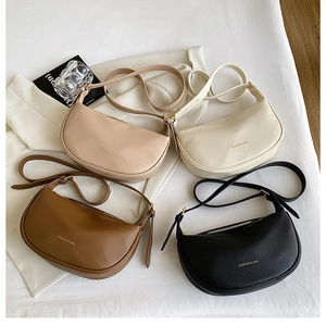 Close-up of crescent shoulder bags in beige, brown and black with litchi grain texture