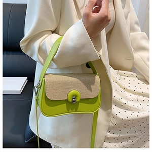 Détail du sac à main vert montrant le rabat tressé et le fermoir à boucle métallique