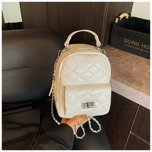Detail of white quilted mini backpack with silver twist lock and metal chain strap