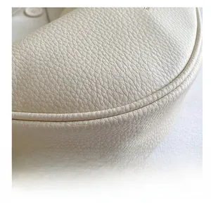 Close-up of premium cream leather texture with detailed stitching on a women's shoulder bag
