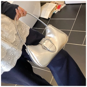 Silver underarm bag featuring a large metallic buckle and sleek synthetic leather texture