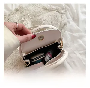 Interior view of cream white mini crossbody bag showing storage space for makeup and items