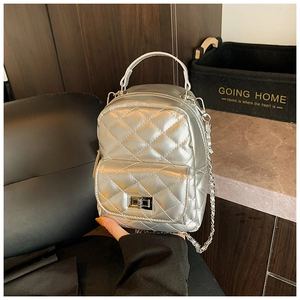 Detail of silver metallic quilted mini backpack with turn-lock and chain strap