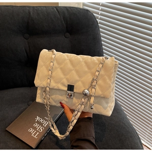 Detail einer gesteppten Ledertasche mit silberner Kette und Metallkugel-Anhänger