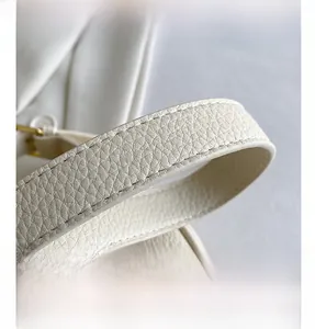 Close-up of white lychee pattern leather strap with neat stitching and golden buckle