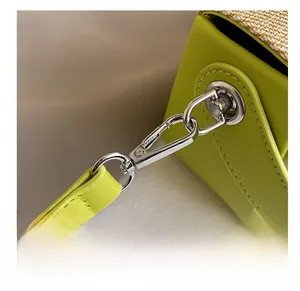 Dettaglio del gancio in metallo argento e tracolla in pelle verde lime intrecciata