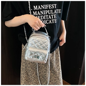 Silver quilted mini backpack detail showing crossbody styling with metal chain strap