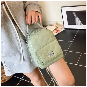 Detail of mint green quilted leather backpack with silver turn-lock and chain strap