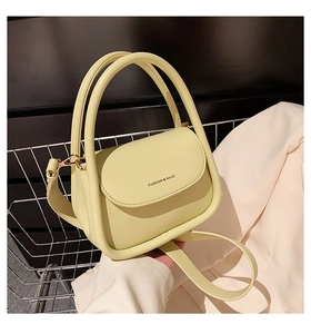 Detail of a light yellow handbag with top handles and Fashion & Bags text in metal basket