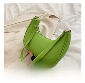 Detail view of fluorescent green crescent moon bag with smooth leather and gold zipper