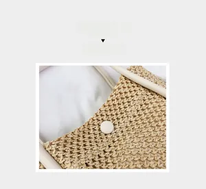 Detail of woven straw handbag featuring cream leather trim and resin button closure