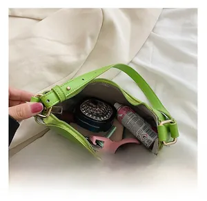 Internal view of green crescent bag showing large capacity for makeup and daily items