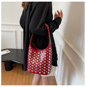 Model wearing red vintage shoulder bag with silver rivet studs and retro embroidery