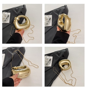 Dettaglio di una pochette da sera dorata a forma di sasso con finitura a specchio