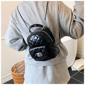 Close-up of a black quilted leather mini backpack with silver chain strap and metal lock