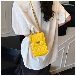 Close-up of vibrant yellow quilted chain bag with gold twist lock on model's shoulder