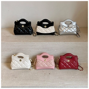 Detail shot of mini quilted crossbody bags in six vibrant colors on stone display