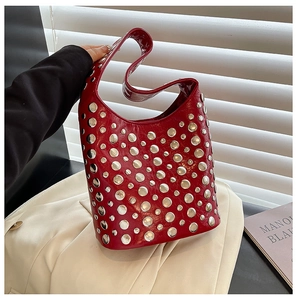 Close-up of red rivet bucket bag with metallic studs and polished leather finish