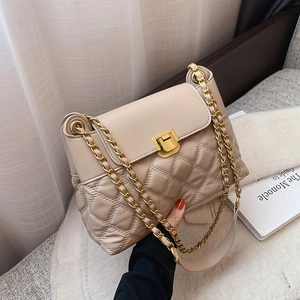 Beige Stepptasche mit goldener Kette und Metallverschluss in eleganter häuslicher Umgebung