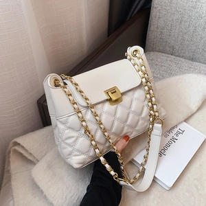 Elegante weiße Stepptasche mit goldener Kette in einer stilvollen Lifestyle-Umgebung